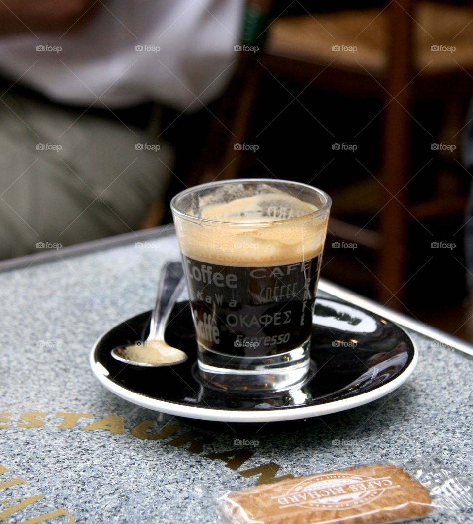 A small cup of espresso in a cozy cafe in the Mares district of Paris , coffee break with a cookie 