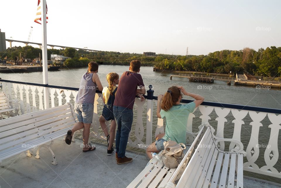 A family enjoys a river boat tour cruise in the Savannah river of Georgia.
