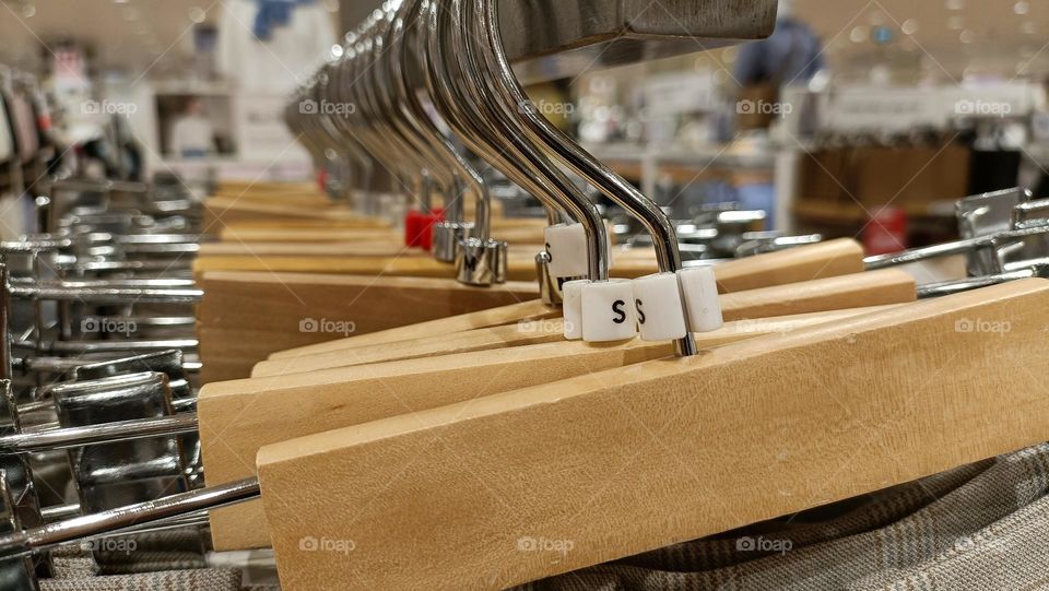 Close up view of hanging clothes arranged on a display rack small size.