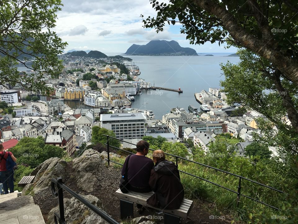 Adult couple sitting in the Alesund park   