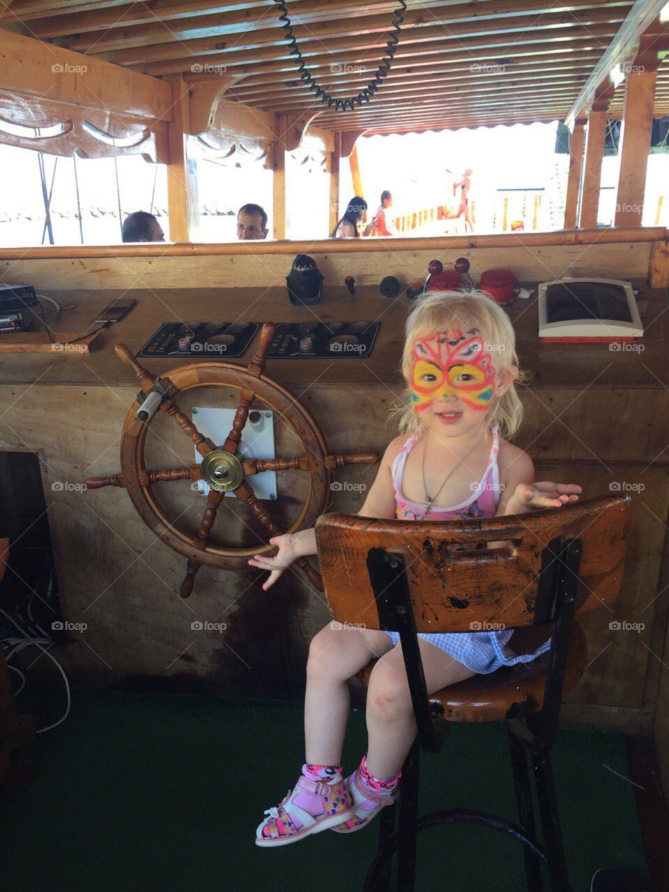 Ребёнок с арт рисунком за штурвалом яхты на море