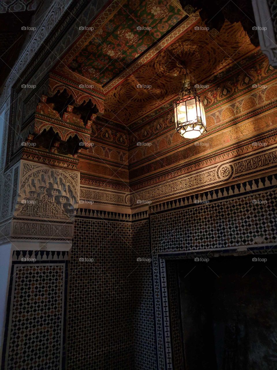 Hanging Lantern Illuminating a Colorful Ceramic Tile Mosaic Cut-Out Wall (Fireplace) in the Bahia Palace in Marrakech in Morocco