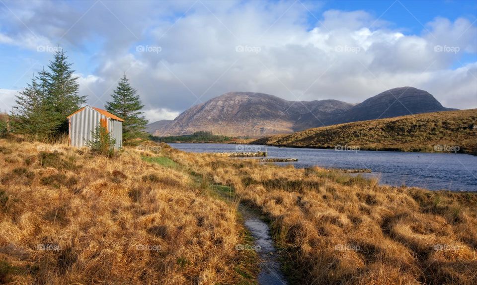 House in wilderness surrounded by river and mountains at Derryclare natural reserve in Connemara National park, county Galway, Ireland