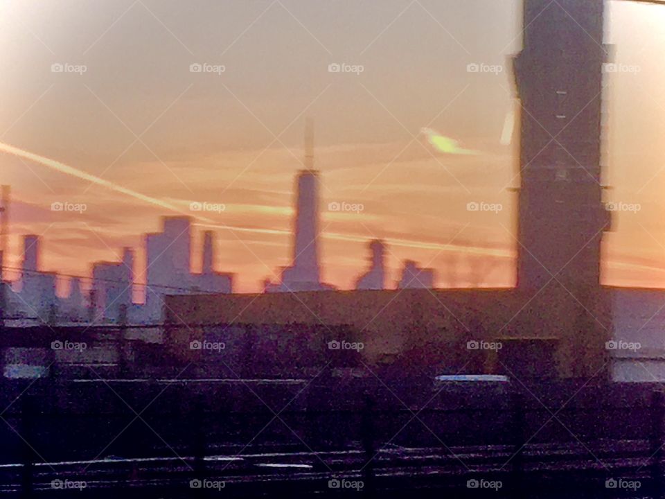 A sunset in Long Island City, Queens, NY. Is the shape in the upper right corner a cloud illuminated from beneath or the moon already rising as the sun goes down? On rare occasions I have seen both the sun and the moon in the sky. Photo from 2019