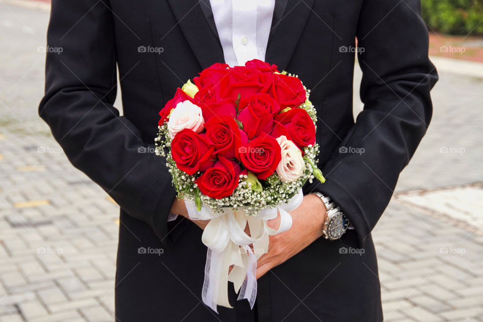 Groom holding flower bouquet