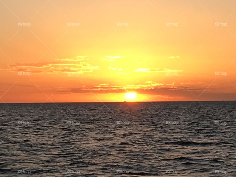 Sun setting over the horizon at sea. 
