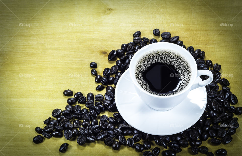 Coffee cup and roasted beans. Coffee cup and roasted beans on wooden background