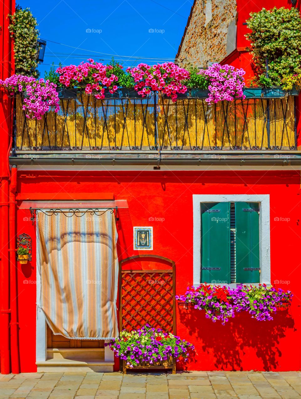 Beautiful exterior of red house with flowerpots on windows 