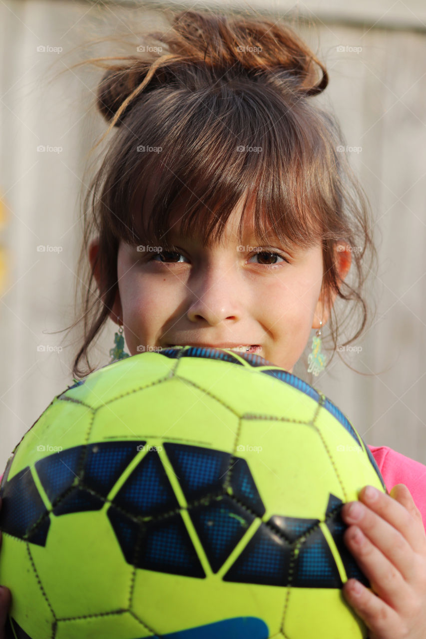 Child holding a soccer ball in her hand