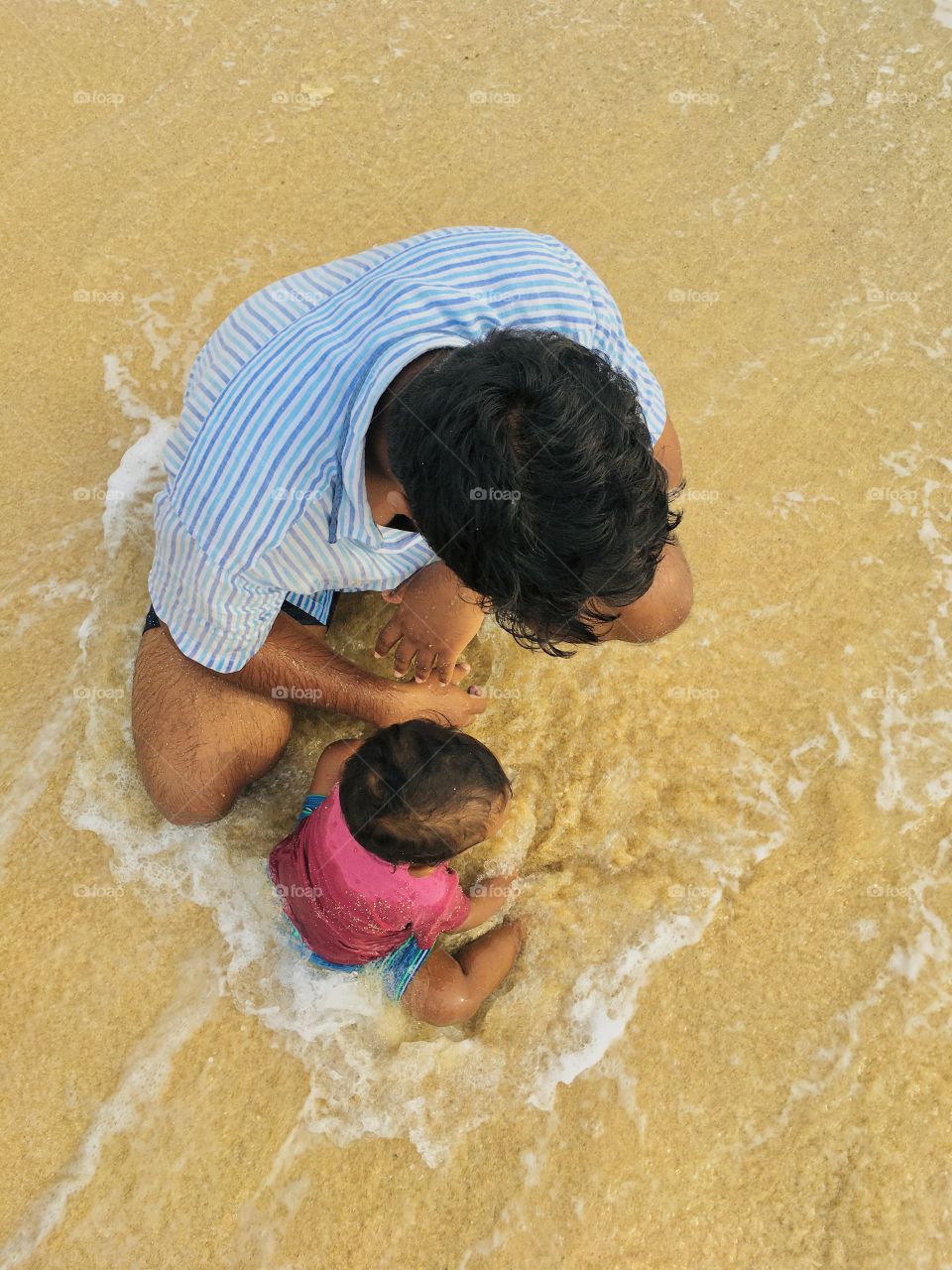 son and father in the evening beach 