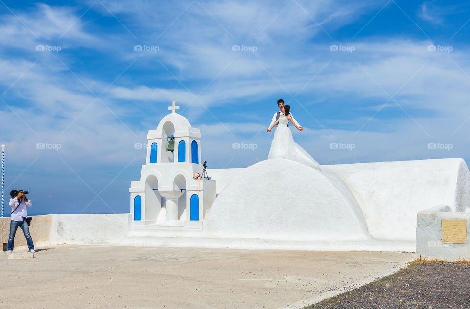 Wedding at Santorini . Wedding photography at beautiful landmark, chapel and blue sky on Santorini, Greece 
