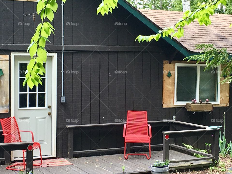 Red chairs on cottage porch