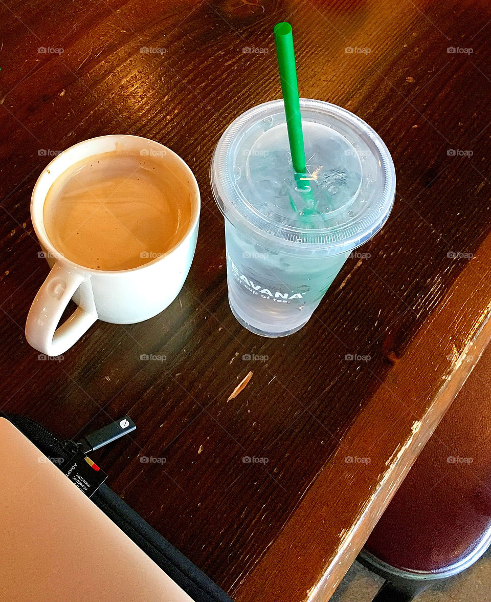 An image showing what many of us do almost daily. A refreshing cup of coffee, ice water, and a laptop make a great combination for many of us at a coffee shop. 