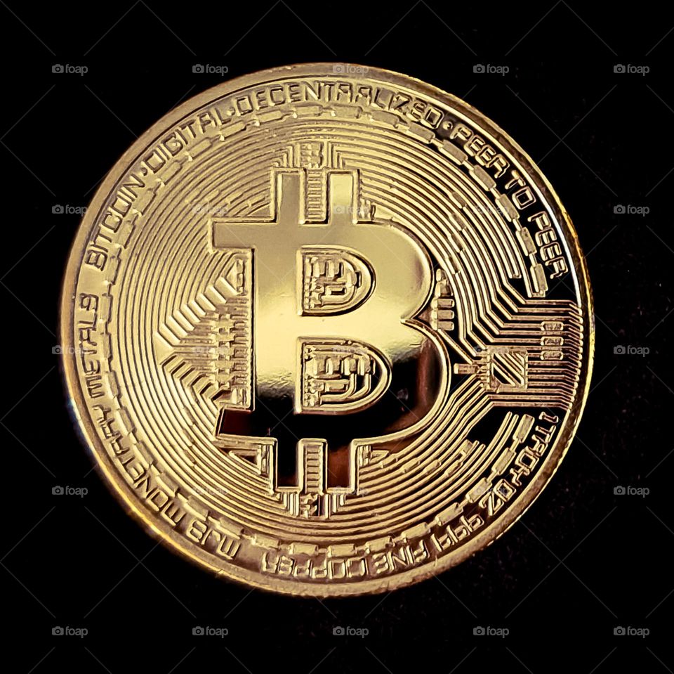 Golden Bitcoin on black background