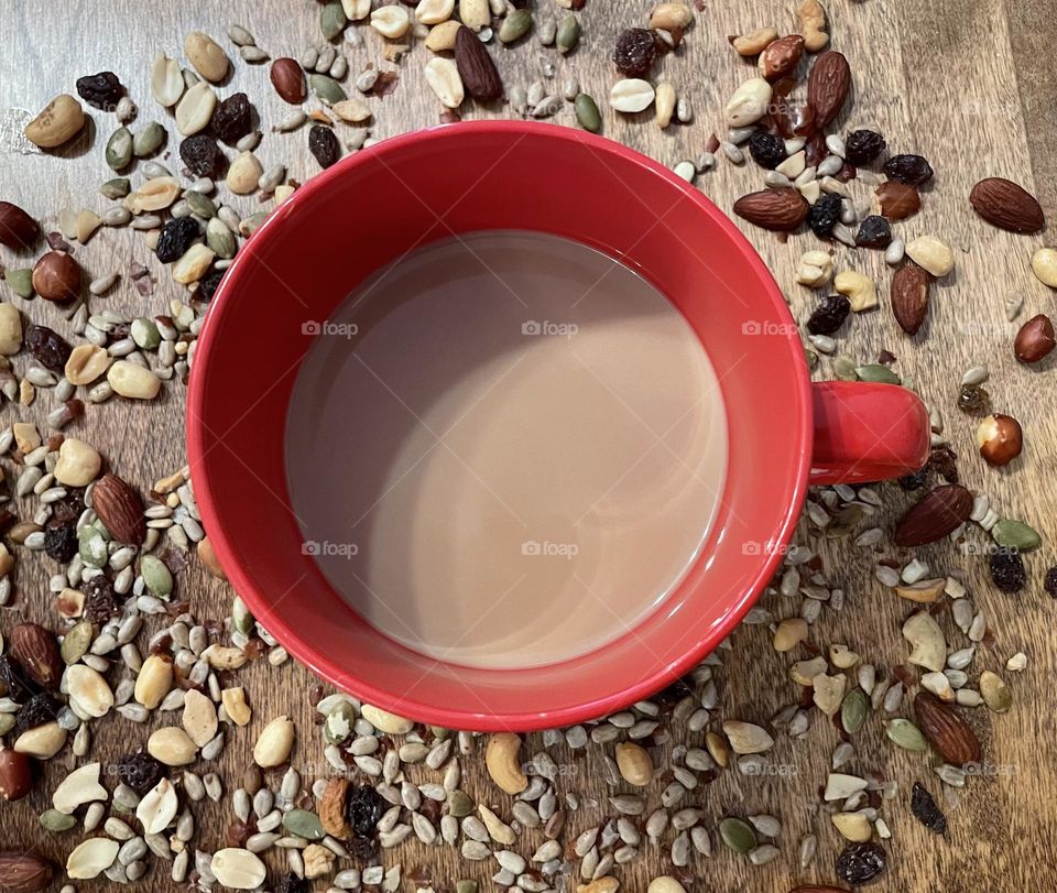 I like my break coffee with cream, in my biggest red mug, with a healthy trail mix, of sunflower seeds, raisins, almonds, peanuts and cashews, which makes this picture a good healthy lifestyle photo