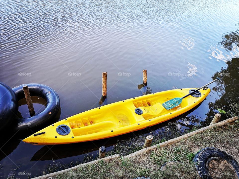Yellow kayak docked on river