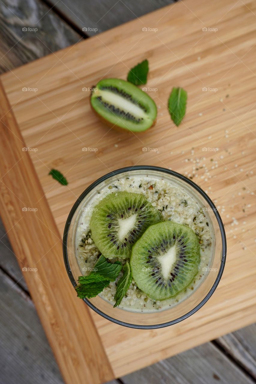 Overhead view of kiwi smoothie with hemp seeds and mint