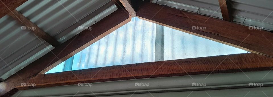 Window frame glowing blue and shining green out to the world, unseen and covered in spiders webs