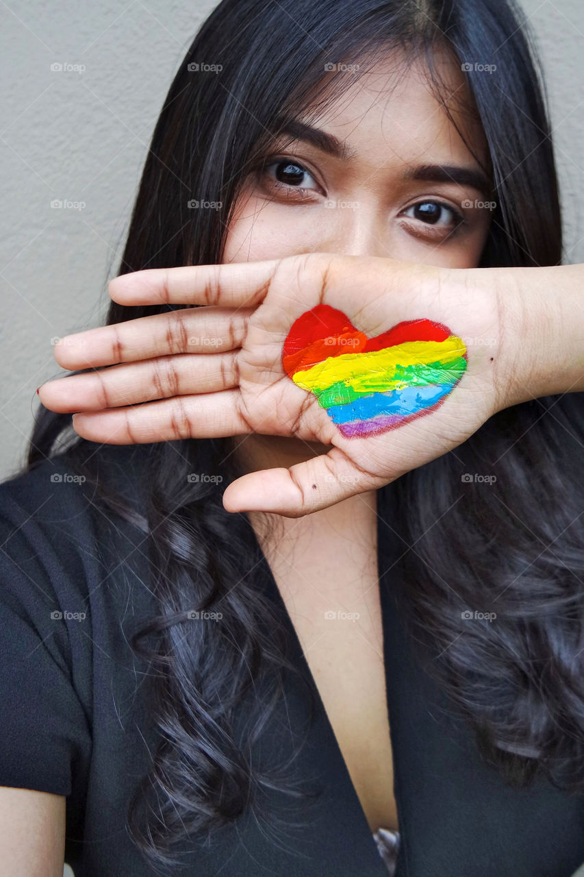 Women with painted rainbow heart 