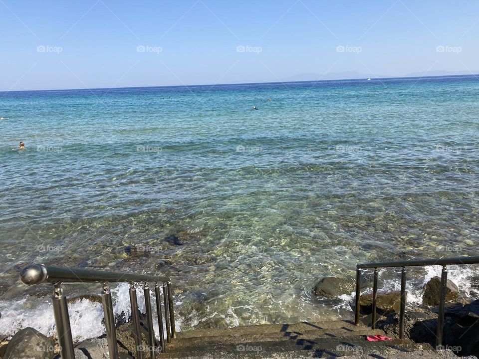 Sunny holidays I’m Turkey. Walk in the cute city and charming streets by the beach in Kusadasi. perfect blue sky and ocean view. Beach and the shore. To travel is to live. Gorgeous tall palm trees.