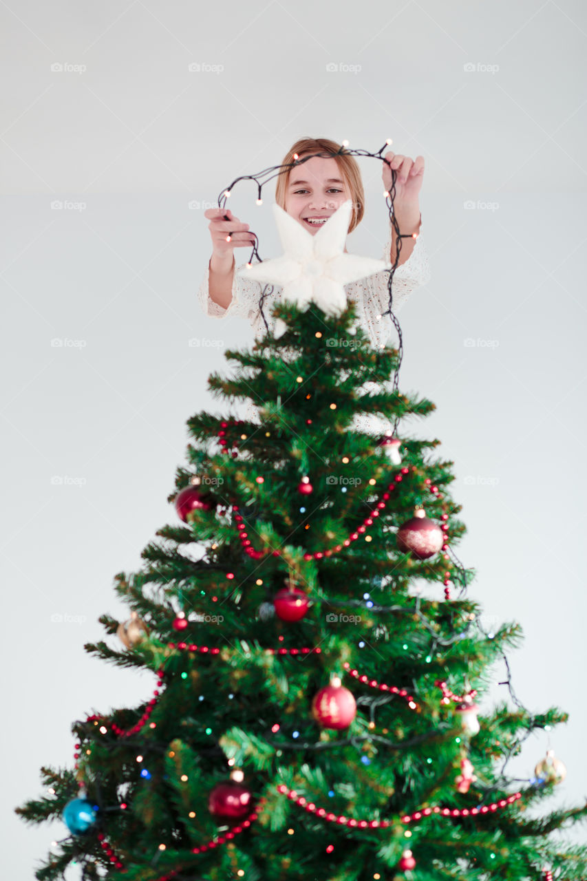 Teenage girl decorating christmas tree
