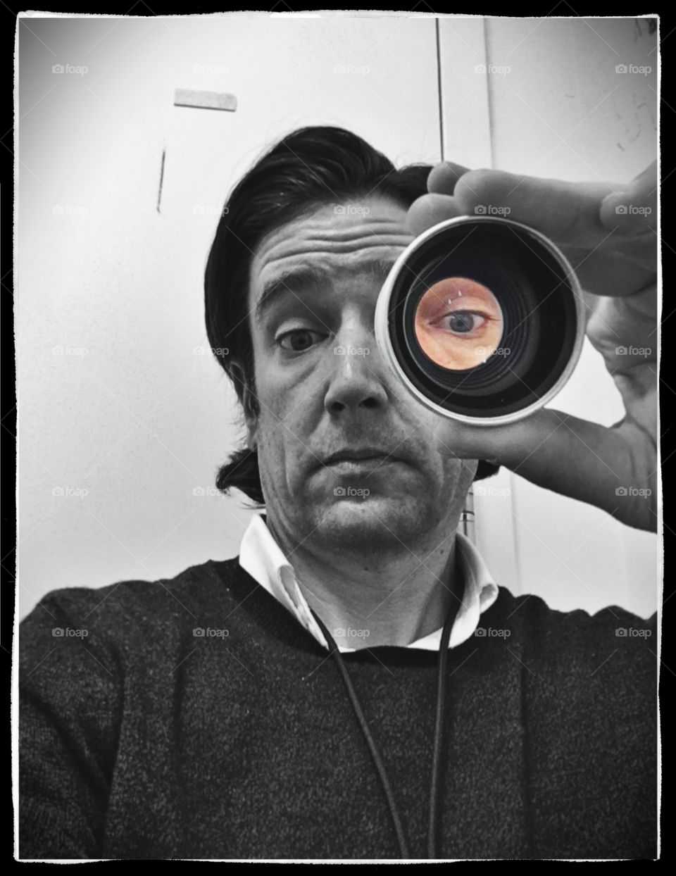 Looking through a cannon lens in black & white with a colored eye