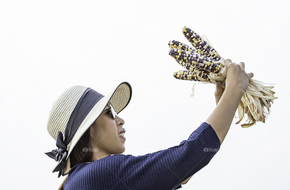 A woman holding the corn at the show in the farm.