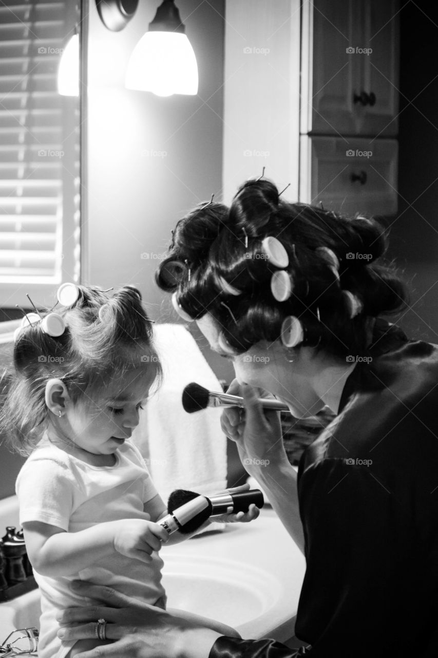 Woman and daughter wearing hair curlers on head
