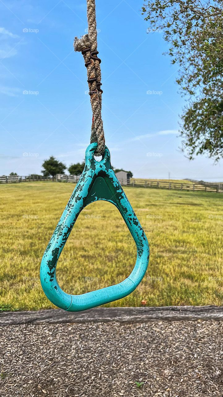 Playground on a farm, old abandoned farm playground, rings on a playground, teal paint chipping