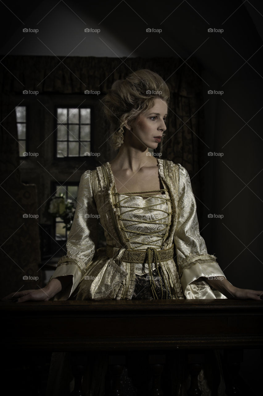 One of a set of photos taken in a 17th century house that is now a restaurant and hotel. The look is based around Marie Antoinette with long luxurious dress and hair styled high. Makeup was very pale and finished using baby powder