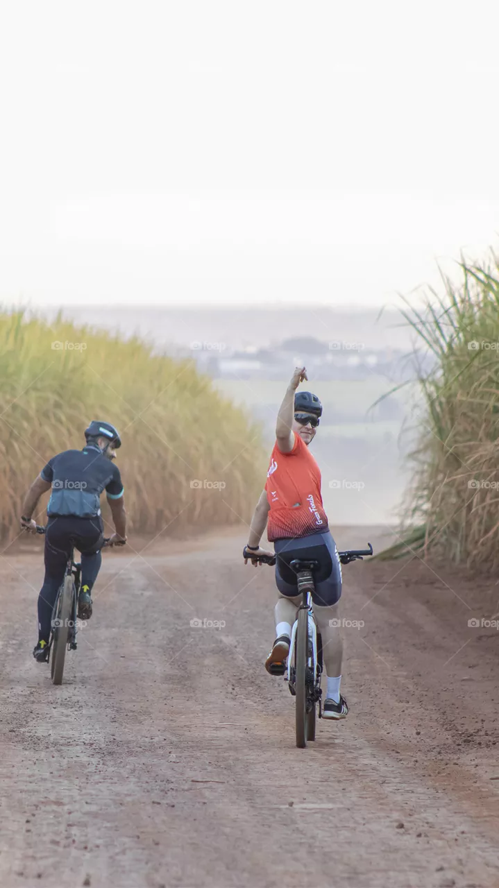Amigos descendo a ladeira de bicicleta feliz.