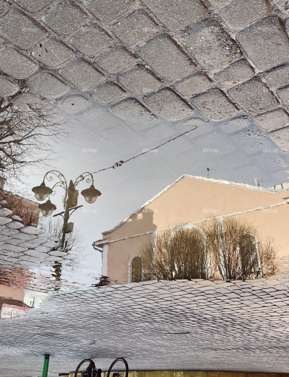 the building is reflected in a puddle