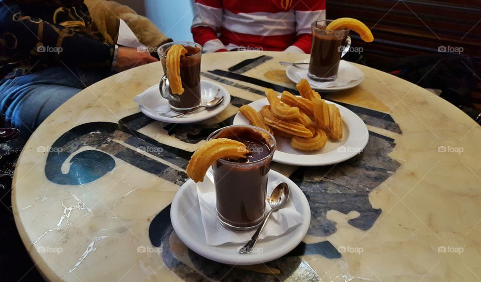Chocolate and churros on table