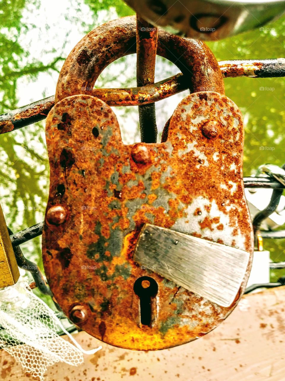 close up of large rusted lock on bridge. wish lock or love lock