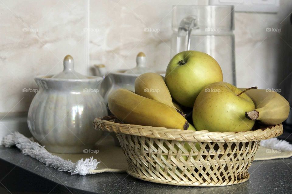 Yellow fruits in the basket on the kitchen table