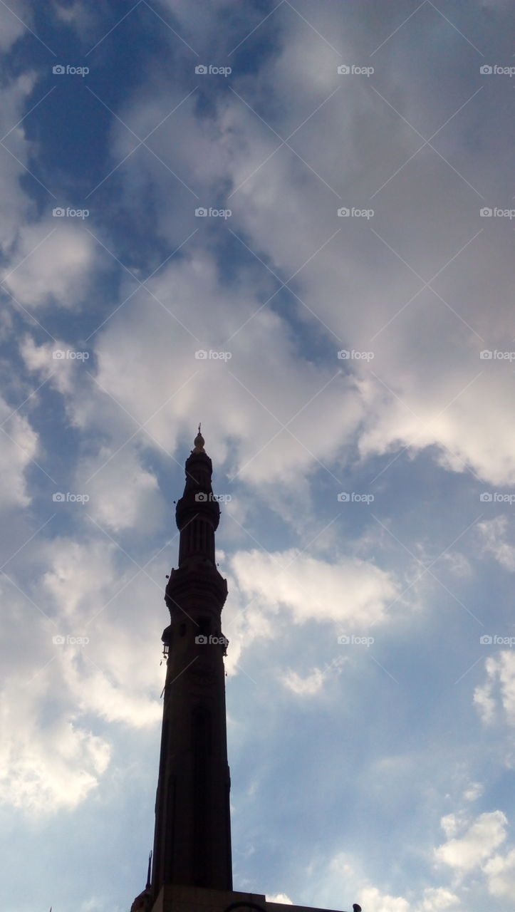 Minaret of a mosque with very dramatic sky view. Cloudy weather.