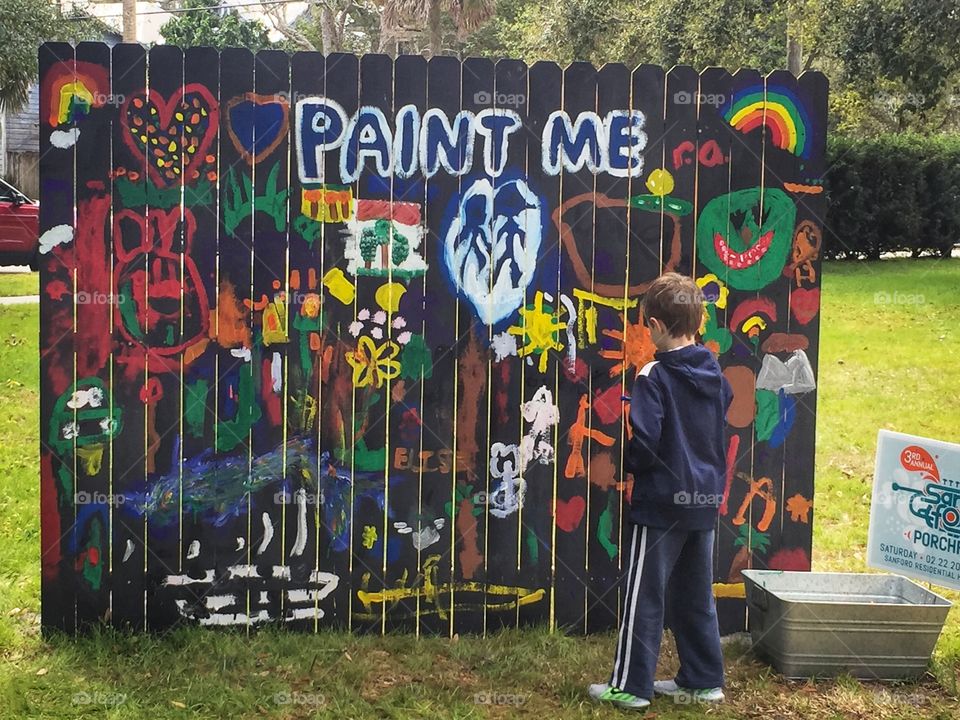 Fun wooden fence for kids to paint their own artwork at an outdoor festival 