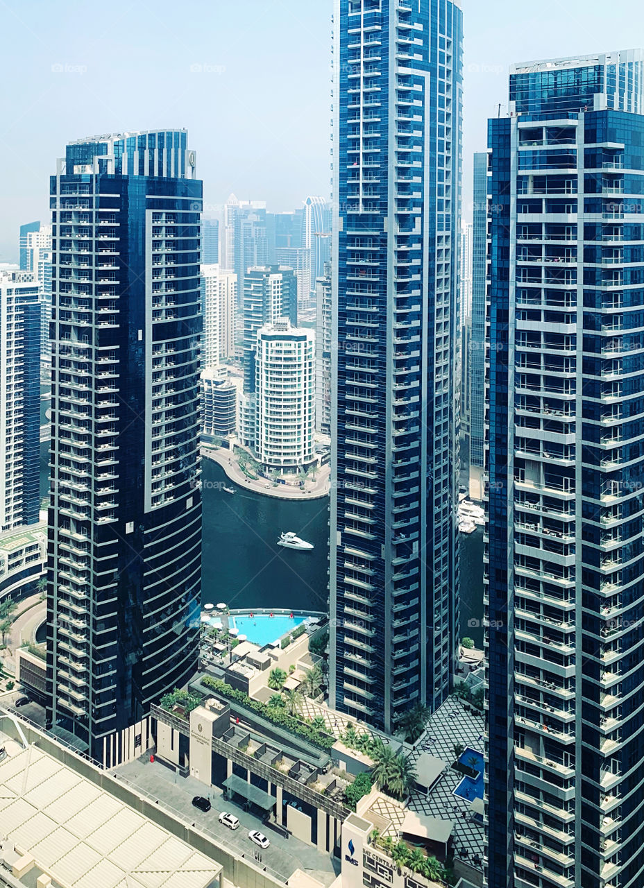 White boat sailing between skyscrapers 