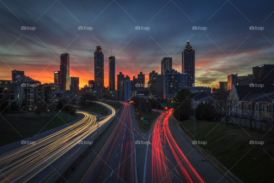 Long exposure of the sun setting behind the Atlanta cityscape taken from the Jackson Street Bridge (company names edited out for commercial use)