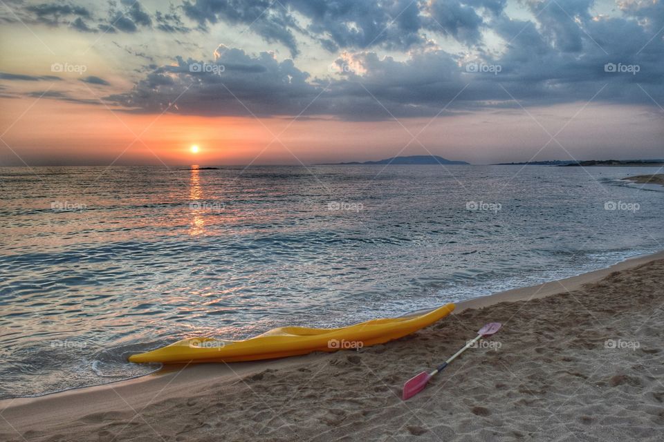 Canoe on beach during sunset