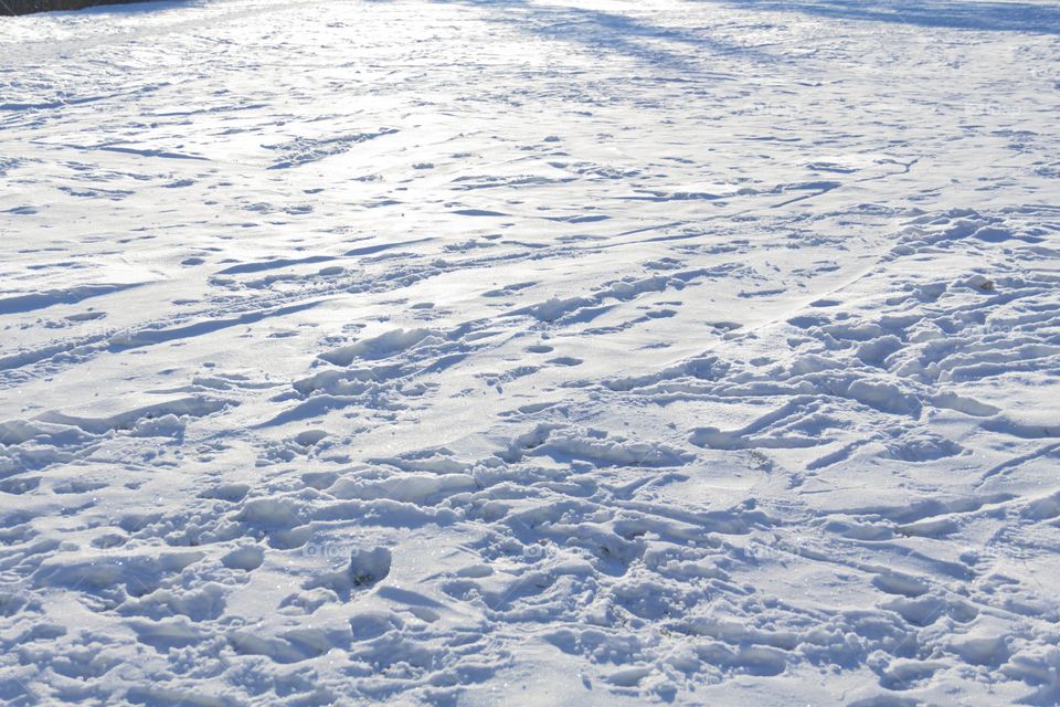 A child in winter in winter jackets, pants, a hat and boots on white snow on the street and in the park in nature plays winter fun and sleds.