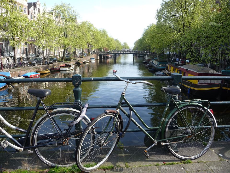 Ride a bicycle in Amsterdam. Enjoy the view on the canals and house boats while Rodung a bicycle.