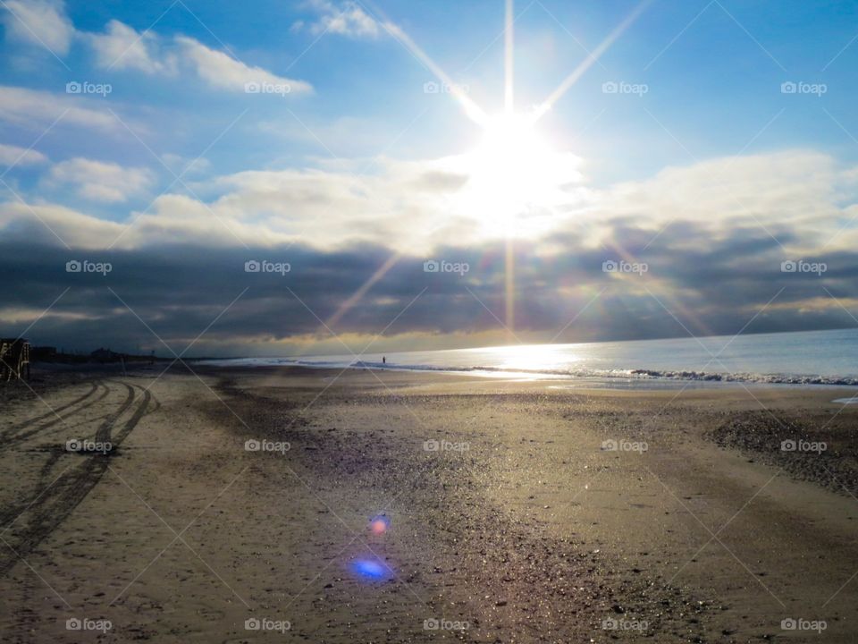 Sun's Up. Sun is fully risen, warm rays shining on beach horizon 