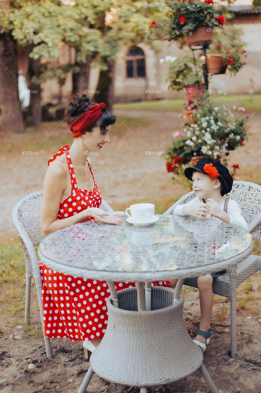 Mother and young son sitting at the table outdoors