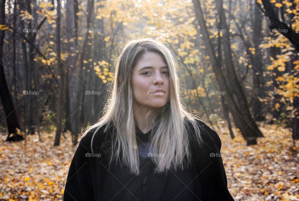 Blonde hair woman under the sumlight in the woods