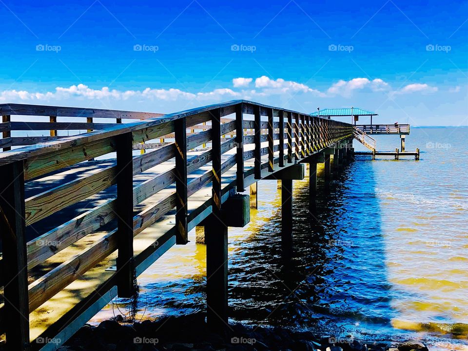 Railings on boardwalk to pier on the water