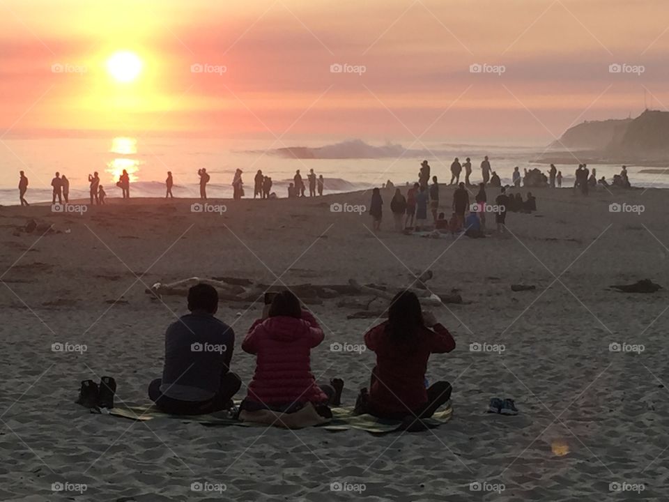 People enjoying sunset on beach