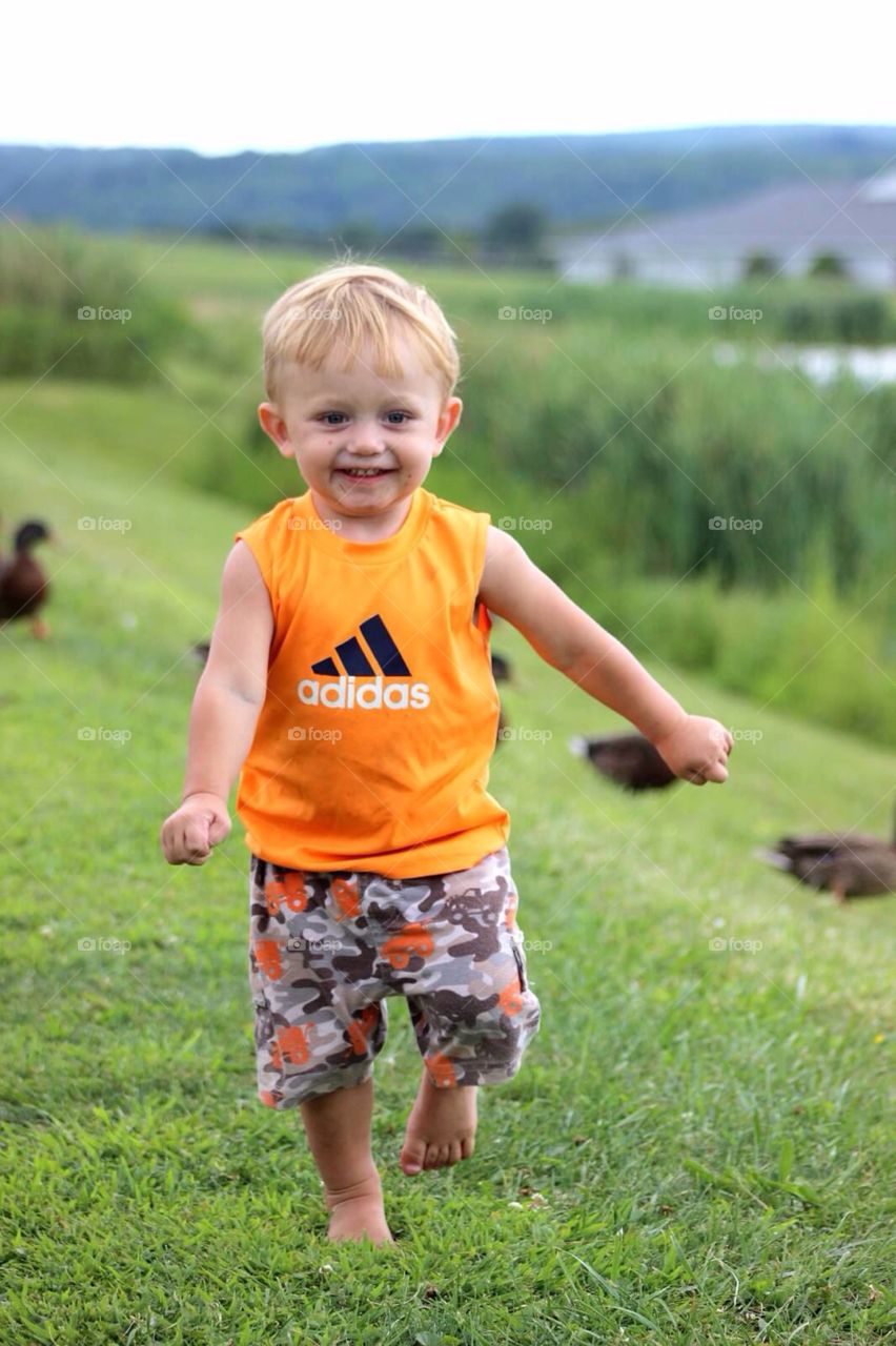 Smiling boy running in grass