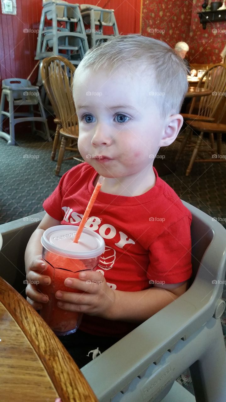 kid holding drink with straw