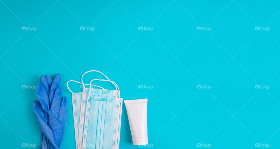 Set of items for personal protection from covid on a blue background. Protection concept. Top view. Copy space